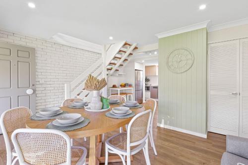 a dining room with a table and chairs at Sunrise Point Beach House by Experience Jervis Bay in Vincentia