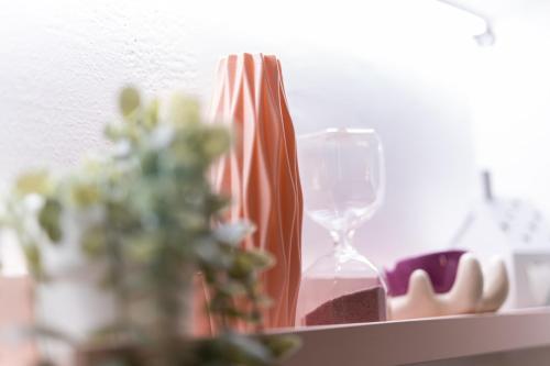 a table with a vase and an empty wine glass at Le fantasie di Tizi in Alpignano