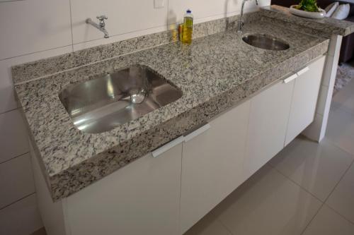 a kitchen counter with a stainless steel sink at Flat inteiro Ônix Bueno in Goiânia