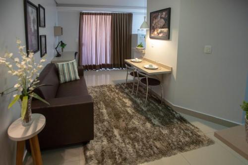uma sala de estar com um sofá e uma mesa em Flat inteiro Ônix Bueno em Goiânia