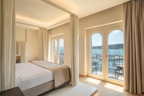 ein Schlafzimmer mit einem Bett und einem großen Fenster in der Unterkunft Bellerive Lifestyle Hotel in Salò