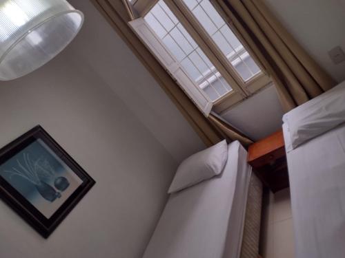 Un pat sau paturi într-o cameră la Pousada Palace Hotel