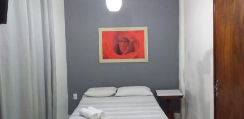 Habitación con cama y pintura en la pared en Pousada Palace Hotel, en Caruaru