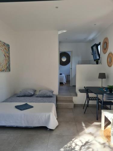 a bedroom with a bed and a dining room at Les chênes verts in Sommières