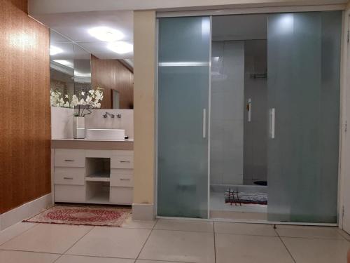baño con ducha y puerta de cristal en Apartamento Copacabana Frente Mar, en Río de Janeiro