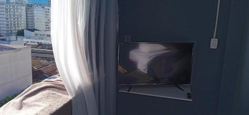 a flat screen tv sitting on a wall next to a window at Lapa Bed and breakfast Apartamento Rio de Janeiro in Rio de Janeiro