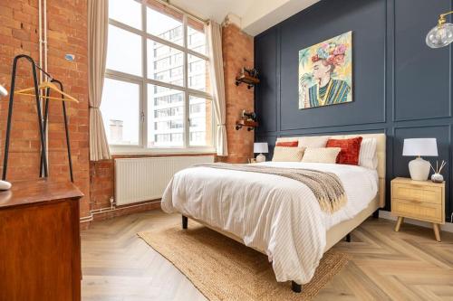 - une chambre avec des murs bleus, un lit et une fenêtre dans l'établissement Stylish, Cosy City Centre Apartment - Free Parking, à Leicester