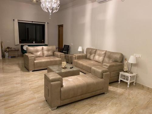 a living room with two couches and a flat screen tv at Jessica’s Vacation Home in Banda