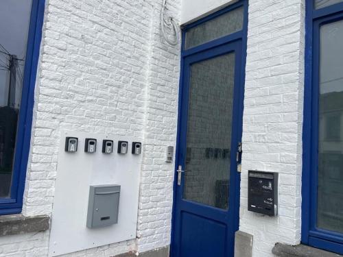 a blue door on the side of a brick building at Station 173 B Bruxelles-Charleroi-airport in Charleroi