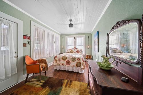 een slaapkamer met een bed, een tafel en een spiegel bij Escape To Willow Springs Inn, Cozy Home Wa View 