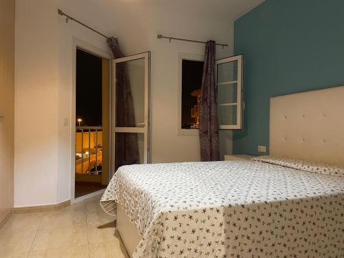 a bedroom with a bed and a large window at Castillo Holiday Home in Caleta De Fuste