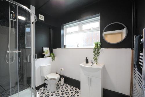 ein Badezimmer mit einem WC, einem Waschbecken und einem Spiegel in der Unterkunft The Good night rooms liverpool 