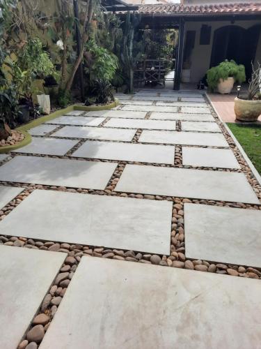 a walkway with stones and plants in a yard at Suíte no jardim - Praia dos Anjos in Arraial do Cabo