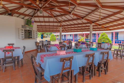 un restaurant avec des tables et des chaises bleues dans une pièce dans l'établissement Hotel Arrayanes del Quindío, à Montenegro