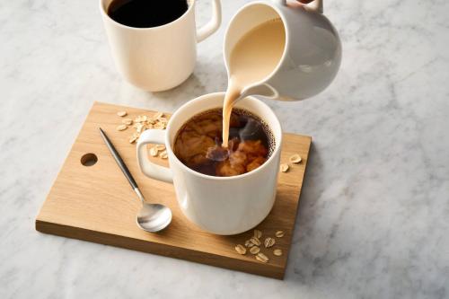 Fairfield Inn & Suites Merrillville في ميريلفيل: جلسة فنجان قهوة على لوح خشبي مع غلاية شاي