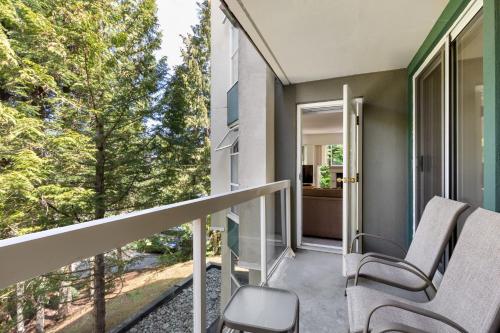 a balcony with two chairs and a large window at The Woodrun Lodge by Whiski Jack in Whistler