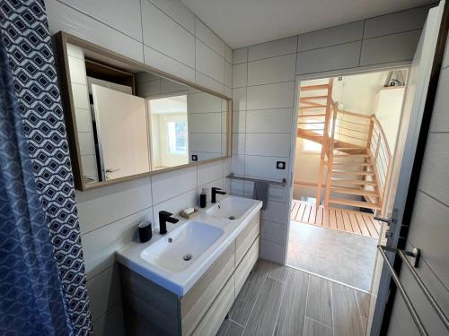 a bathroom with a sink and a mirror and a staircase at La Maison de Juliette in Le Puy en Velay