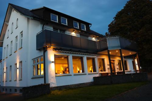 uma grande casa branca com muitas janelas em Lübkes Ferienwohnungen & Apartments em Allendorf