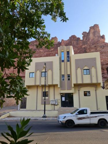 a white truck parked in front of a building at Wind alula in AlUla