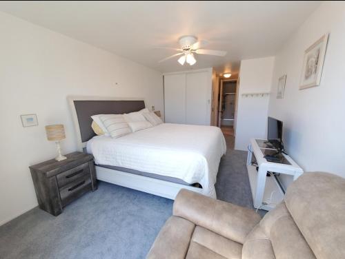 een slaapkamer met een wit bed en een bank bij Luxury 1 bedroom and 1 bath condominium with amazing OCEAN VIEWS in Oceanside