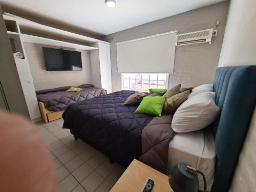 um quarto com uma cama com almofadas verdes em Avellaneda Apart 3 em Mendoza