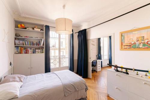 une chambre avec un lit et une grande fenêtre dans l'établissement Family apartment center paris 8th- by AskMeFrance, à Paris