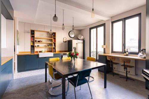 une cuisine avec une table et des chaises dans une pièce dans l'établissement Family apartment center paris 8th- by AskMeFrance, à Paris
