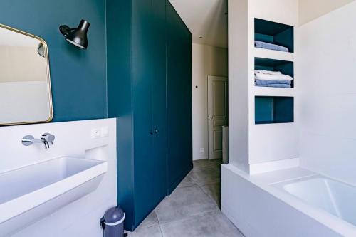 La salle de bains est pourvue d'un lavabo blanc et d'un mur vert. dans l'établissement Family apartment center paris 8th- by AskMeFrance, à Paris