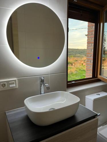 W łazience znajduje się biała umywalka i lustro. w obiekcie La Traviesa de la Demanda w mieście Cabezón de la Sierra