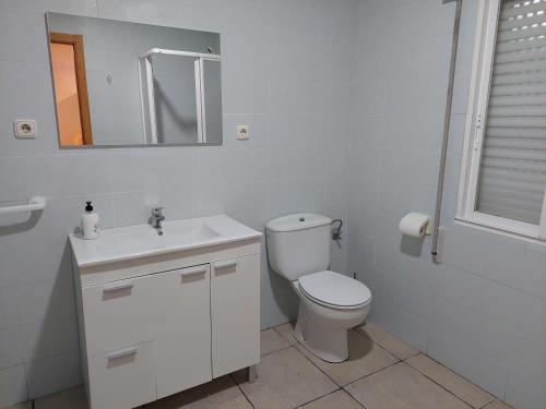uma casa de banho com um WC, um lavatório e um espelho. em Casita en la playa em Boiro