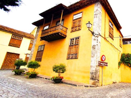a yellow building with a balcony on a street at Canarian House Casa Esther in Icod de los Vinos in Icod de los Vinos