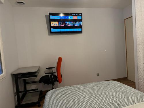 a bedroom with a bed and a desk and a television on the wall at Chambre privée-Clim-TV-Confort-Breakfast inclus in Nevers