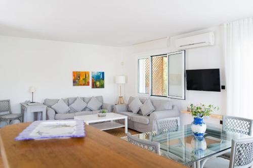 a living room with a table and a couch at Iliana Exclusive Villa - Private Pool - Walking Distance To Beach in Porto Heli