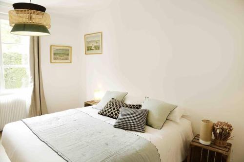 - une chambre avec un lit blanc et des oreillers dans l'établissement Paddock Prestige by La Boîte En Plus, à Chantilly