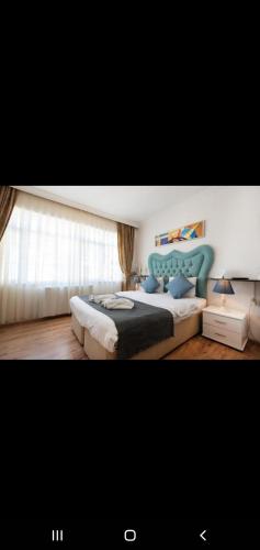 ein Schlafzimmer mit einem großen Bett mit blauem Kopfteil in der Unterkunft 3 FLOOR OLD CITY 3 in Istanbul