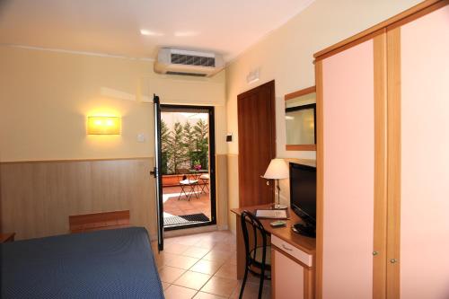 a room with a table and a desk with a television at Villa Santacroce in San Giovanni Rotondo