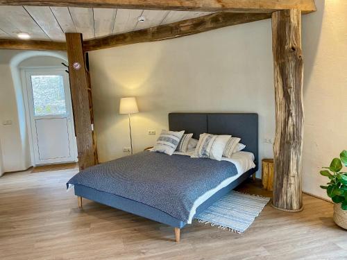 um quarto com uma cama num quarto com vigas de madeira em Kupolinis namelis 
