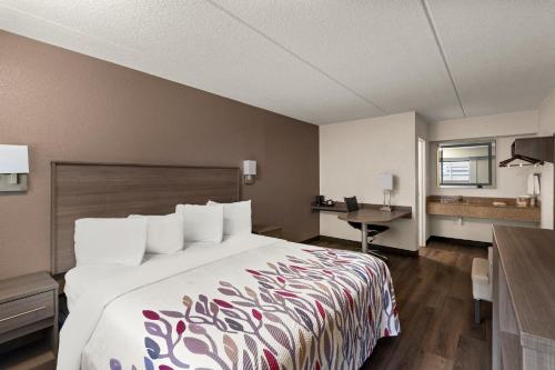 ein Hotelzimmer mit einem Bett und einem Schreibtisch in der Unterkunft Red Roof Inn Binghamton - Johnson City in Binghamton