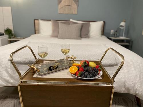 - un plateau de fruits et des verres à vin sur le lit dans l'établissement Relaxing Suite For Two With Jacuzzi, à Pacific