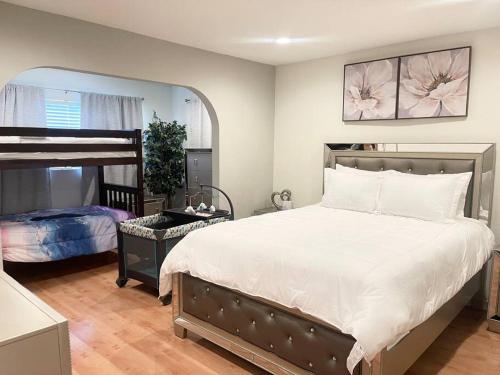 um quarto com uma grande cama branca e um quarto com uma cama quadrada em New HB Family Vacation Home em Midway City