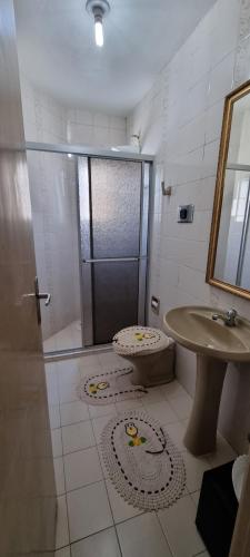 a bathroom with a shower and a toilet and a sink at Apartamento em Tramandaí in Tramandaí