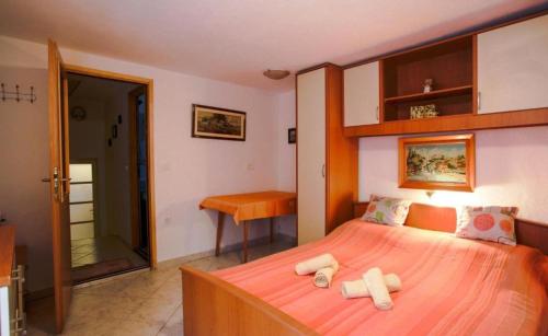 a bedroom with a bed with two towels on it at House Golovik in Brseč