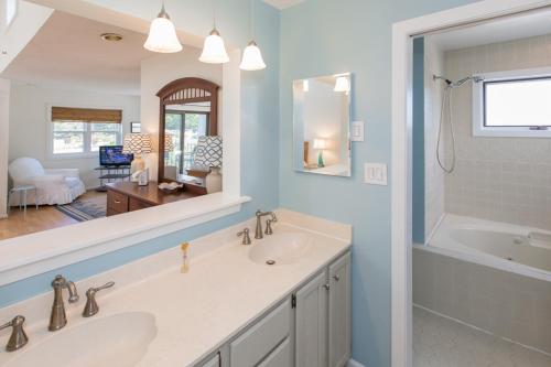 維吉尼亞海灘的住宿－Beaches and Dreams - North End VB，一间带两个盥洗盆和大镜子的浴室