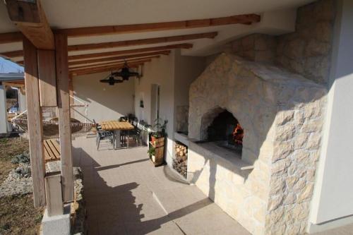 an outdoor patio with a large stone fireplace at House Green Oaza in Zadvarje