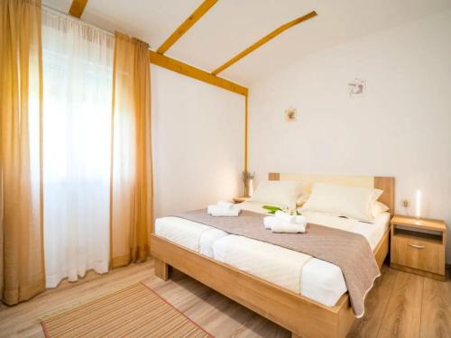 a bedroom with a bed with two towels on it at House Green Oaza in Zadvarje