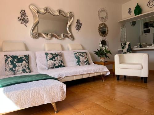 a living room with a couch and a mirror at La casita de la piscina in Adeje