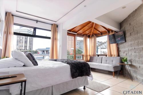 a bedroom with a large bed and a couch at Hotel Citadin in Guatemala