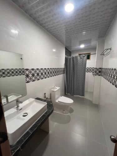 a white bathroom with a sink and a toilet at Rihiveli Residence Thoddoo in Thoddoo