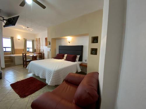 um quarto com uma cama e um sofá em Hotel El Relicario em Dolores Hidalgo