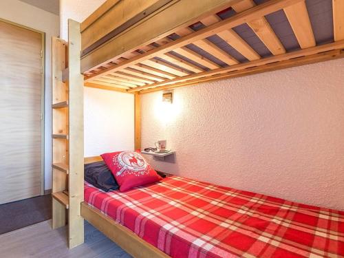 - une chambre avec des lits superposés et un oreiller rouge dans l'établissement Studio rénové skis aux pieds avec balcon, 4 pers, Reberty 1850 - FR-1-344-852, aux Menuires